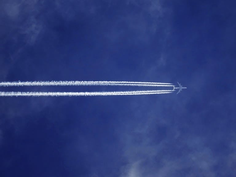 A jet airplane leaves trails in a clear blue sky