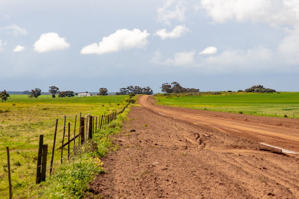 Scenic view of a dirt road through green farmland in rural South Africa.